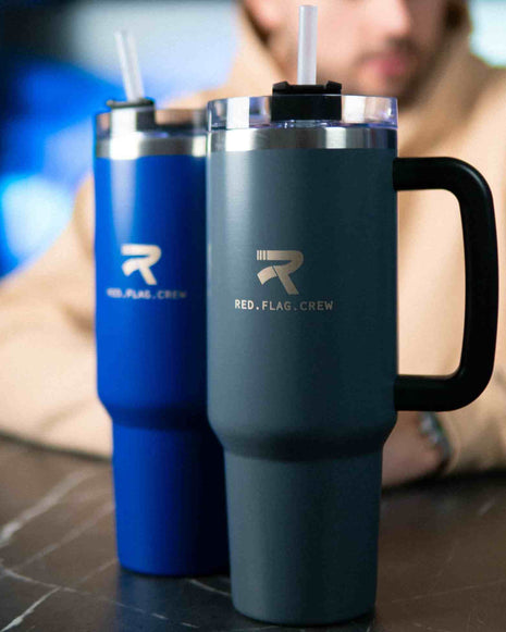 Vegas XXL Exkluzív double-walled stainless steel RFC bottle 1200ml in elegant dark blue and classic silver with engraved logo on a table.
